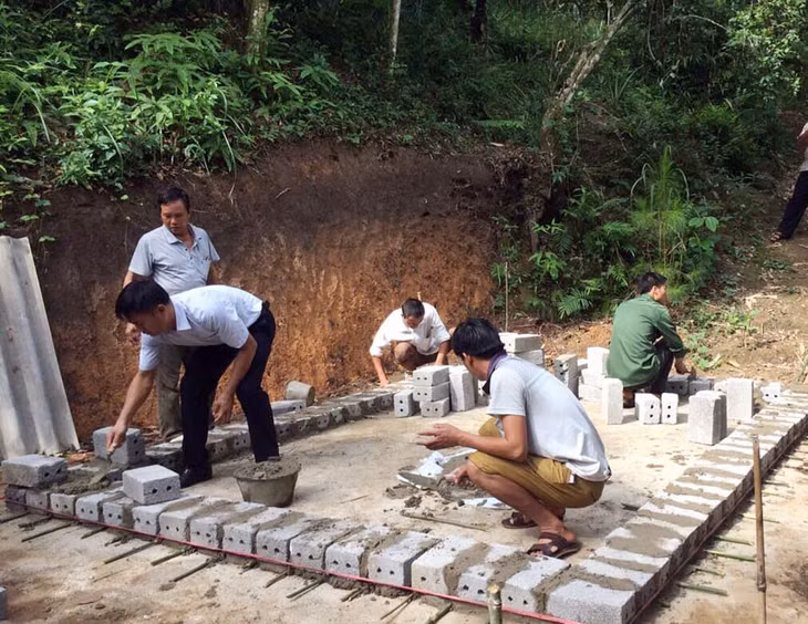 Cán bộ xã Đồng Tâm, huyện Bình Liêu hướng dẫn người dân thôn Phiêng Chiểng xây dựng chuồng trâu thoát nước tự động.