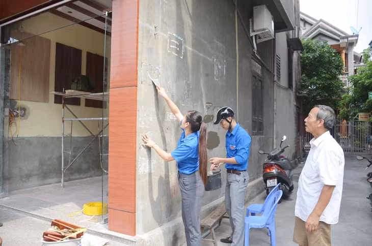 ĐVTN phường Thanh Sơn giúp gia đình ông Nguyễn Quang Huân xóa quảng cáo rao vặt ở tường nhà
