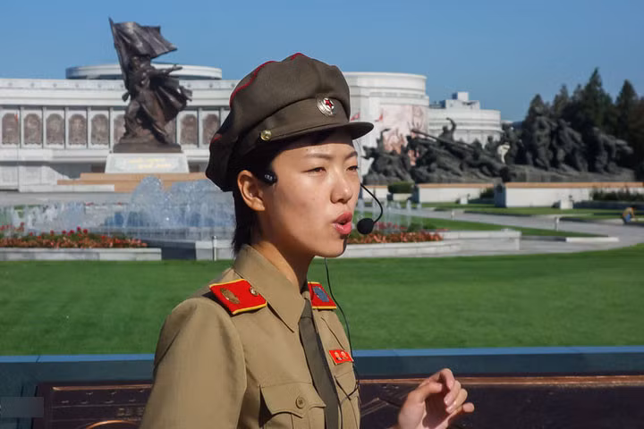 Hướng dẫn viên thuyết minh về Chiến tranh Triều Tiên theo góc nhìn Triều Tiên. Phía sau là “Bảo tàng Chiến tranh Giải phóng Tổ quốc Chiến thắng”.