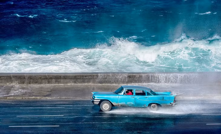 Một chiếc xe cổ chạy dọc theo con đường sát bờ biển, ở Havana, Cuba. (Nguồn: NatGeo)