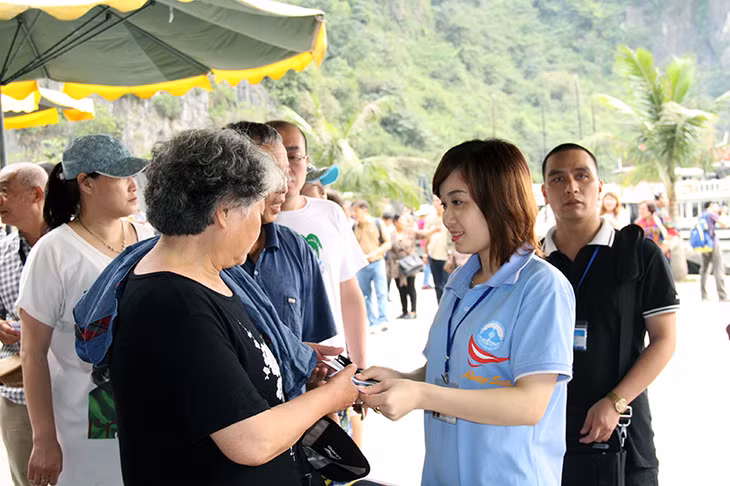 Nụ cười thân thiện của nhân viên Ban Quản lý Vịnh Hạ Long khi tiếp đón du khách.