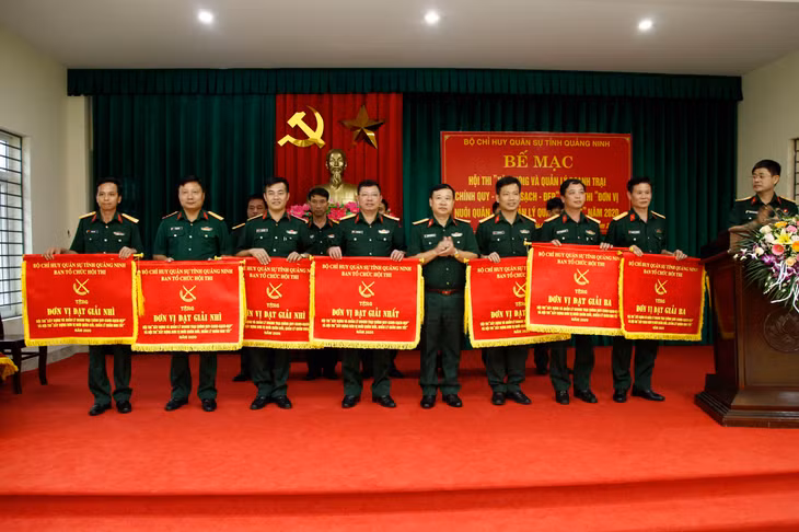 Đại tá Nguyễn Thanh Bình, Phó Chỉ huy trưởng Bộ CHQS tỉnh, trao cờ cho các đơn vị đạt Nhất, Nhì, Ba.