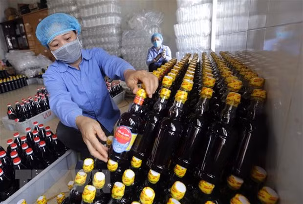 Dán mác sản phẩm nước mắm Ninh Cơ tại Công ty. (Ảnh: Trần Việt/TTXVN)
