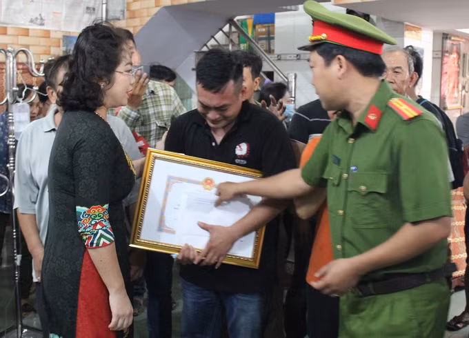 Bà Vy Vũ Hồng Thảo tặng bằng khen cho gia đình anh Quang tối 15/10. Ảnh: Thái Hà