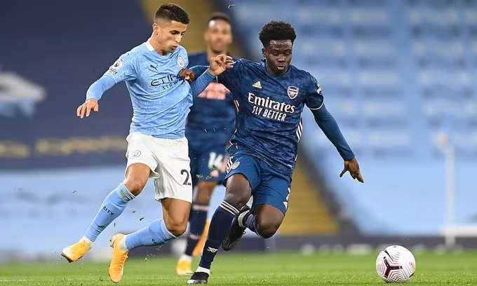 Saka (phải) hai lần dứt điểm hướng khung thành, nhưng không đánh bại được Ederson. Ảnh: Reuters