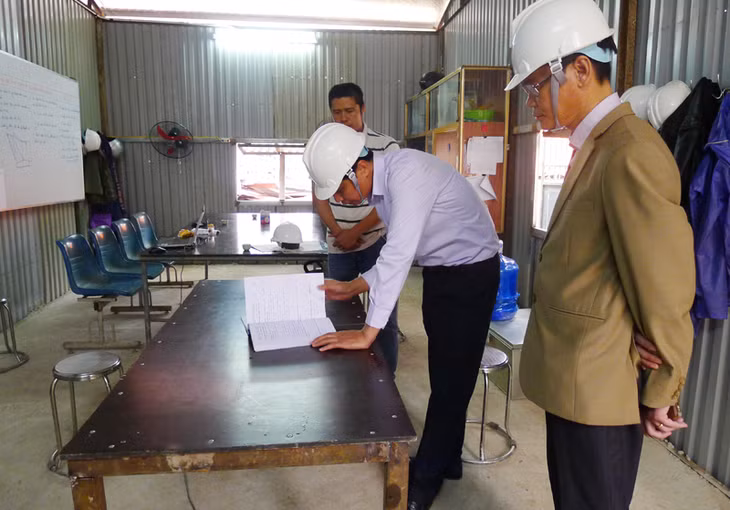 Đồngg chí Vũ Văn Diện, Phó Chủ tịch UBND tỉnh kiểm tra nhật ký thi công xây dựng công trình nâng cấp, mở rộng Trung tâm y tế huyện Hoành Bồ