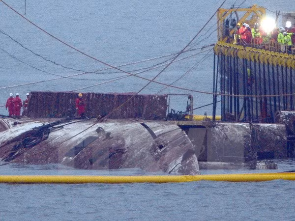 Lực lượng cứu hộ làm nhiệm vụ trục vớt phà Sewol trên vùng biển gần Jindo, cách Seoul 472km về phía tây nam ngày 23/3. (Ảnh: Yonhap/TTXVN)