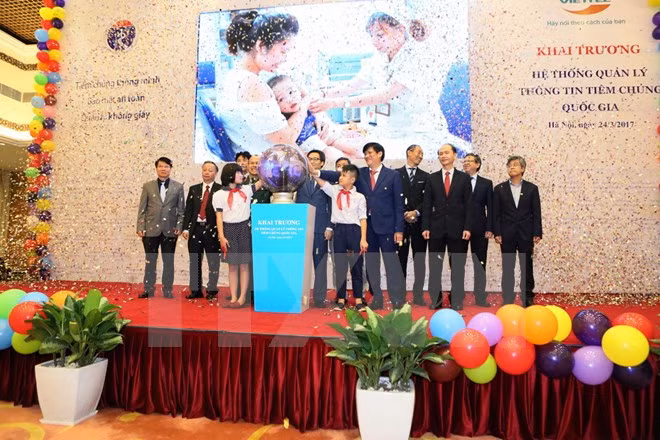 Các đại biểu bấm nút khai trương Hệ thống quản lý thông tin tiêm chủng quốc gia. (Ảnh: Thành Đạt/TTXVN)