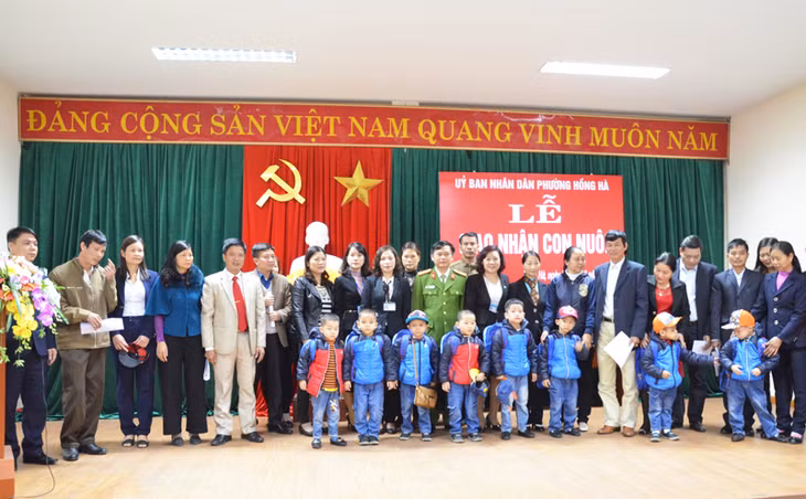 8 TE được nhận làm con nuôi chụp ảnh lưu niệm cùng gia đình và lãnh đạo các sở, ngành liên quan của tỉnh