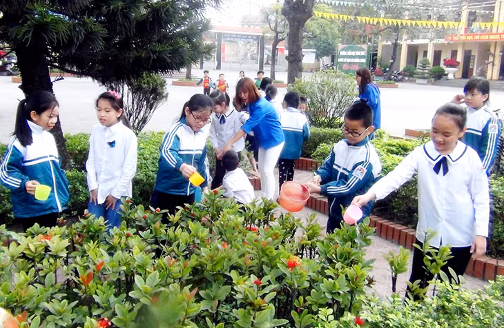 Học sinh lớp 3C8, Trường Tiểu học Vĩnh Khê (TX Đông Triều) chăm sóc vườn hoa của trường.