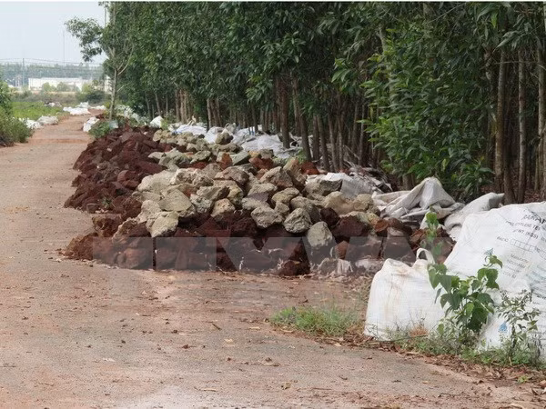 Hàng ngàn bao tải chứa chất thải và các khối chất thải được đổ dọc hai bên đường. (Ảnh: Lê Xuân/TTXVN)