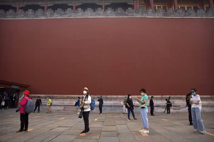 Du khách đeo khẩu trang và thực hiện giãn cách khi tham quan. Ảnh: AP/Mark Schiefelbein.