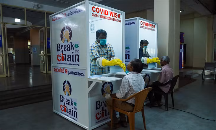 Nhân viên y tế lấy mẫu tại quầy xét nghiệm nCoV ở đại học y Ernakulam, bang Kerala, Ấn Độ, ngày 20/4. Ảnh: AFP.