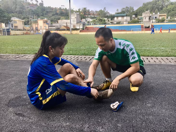 Bác sĩ Hoàng kiểm tra và sơ cứu chấn thương cho cầu thủ.