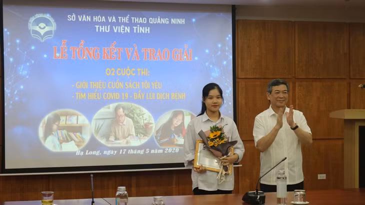 Ban tổ chức trao giải cho thí sinh đạt giải nhất cuộc thi “Tìm hiểu về Covid- 19 - Đẩy lùi dịch bệnh” .