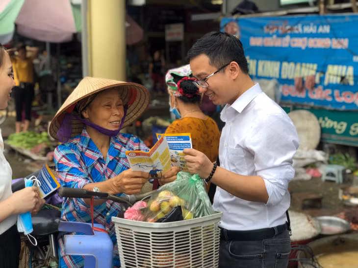 Cán bộ BHXH tuyên truyền lưu động về lợi ích khi tham gia BHXH tự nguyện.