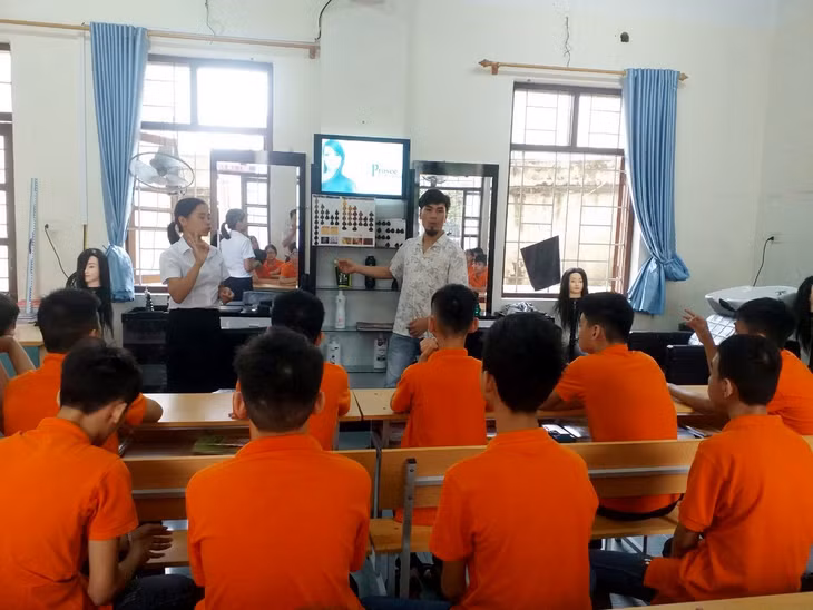 Anh Vũ Ngọc Duy (áo trắng) dạy các kỹ thuật cắt tóc cho trẻ em bị khiếm thính tại Cơ sở bảo trợ, chăm sóc trẻ em có hoàn cảnh đặc biêt tỉnh.