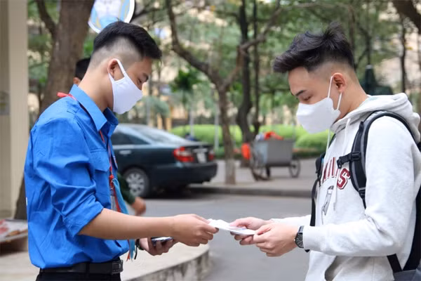 Sinh viên ĐH Khoa học Xã hội và Nhân văn (Hà Nội) được phát hướng dẫn các bước vệ sinh phòng dịch trong ngày đầu đi học lại. Ảnh: Lê Huyền