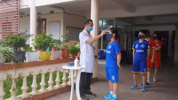 ... và đo thân nhiệt cho các cầu thủ trước khi ra sân.