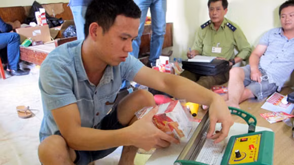 Nhân viên của Đỗ Thị Tuyết Mai mô tả việc dán tem nhãn sản phẩm trước sự chứng kiến của cơ quan chức năng