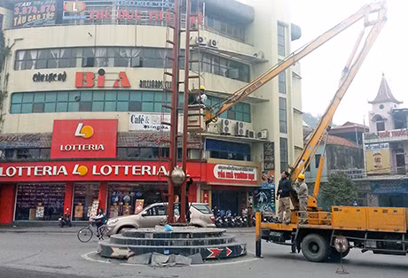Công nhân Công ty CP Môi trường đô thị Cẩm Phả sửa chữa hệ thống đèn chiếu sáng tại khu vực Ngã tư Tổng hợp.