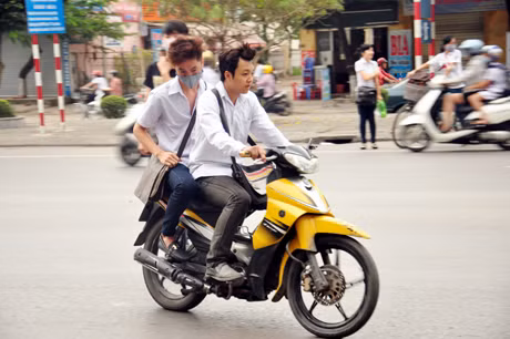 Ngang nhiên đi xe máy đến trường, không đội mũ bảo hiểm.