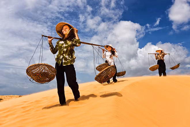 Các cô gái băng qua đồi cát nóng ran ở tỉnh Ninh Thuận. Dù thời tiết miền Trung có phần khắc nghiệt, cả ba vẫn cười tươi tắn, không để lộ vẻ mệt mỏi.