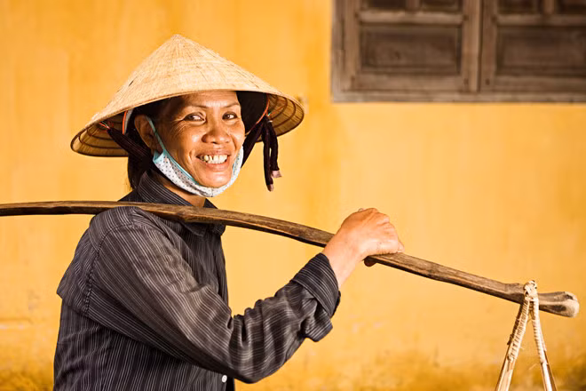 Chiếc nón lá và gánh hàng rong là một trong những hình ảnh quen thuộc của đất nước hình chữ S. Dẫu gánh nặng có oằn trên đôi vai gầy thì nụ cười hiền hòa vẫn luôn thường trực trên gương mặt.