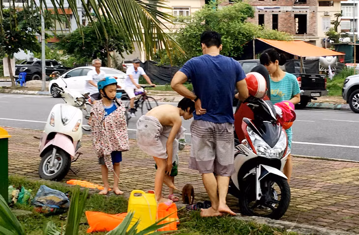 Người dân sử dụng luôn vỉa hè làm nơi thay quần áo cho trẻ nhỏ.
