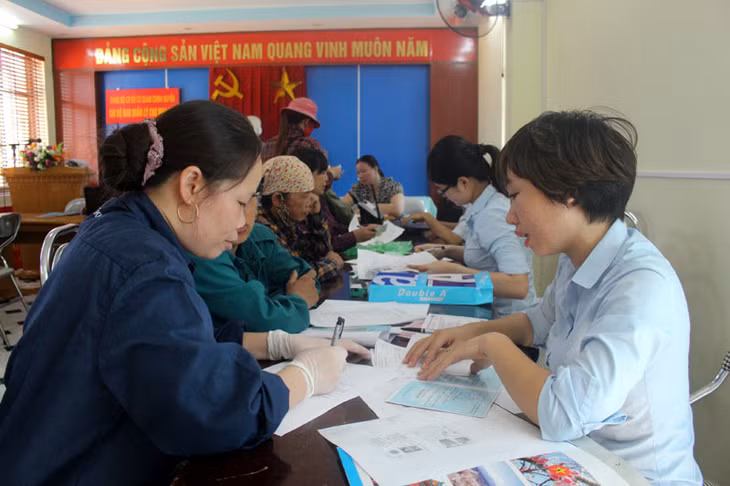 Cán bộ Trung tâm hành chính công TX Đông Triều giải quyết thủ tục hành chính lưu động cho các hộ kinh doanh của chợ Mạo Khê.