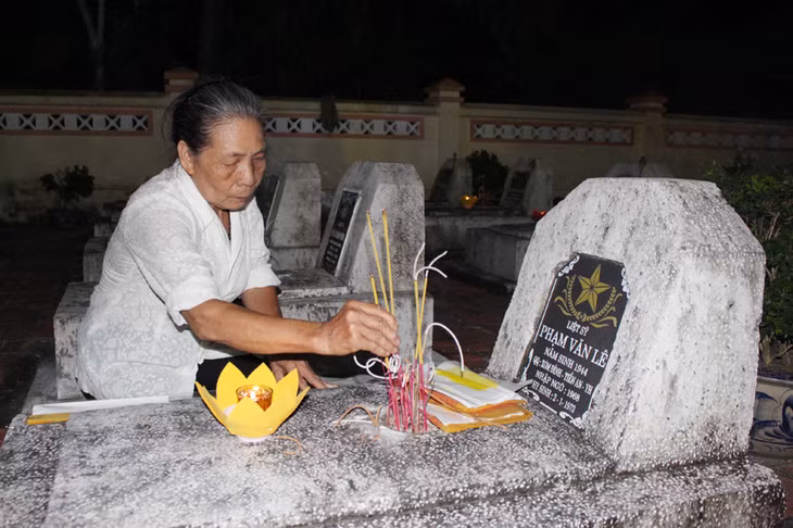 Thân nhân gia đình liệt sỹ đến thắp hương, tri ân tại phần mộ liệt sỹ. 