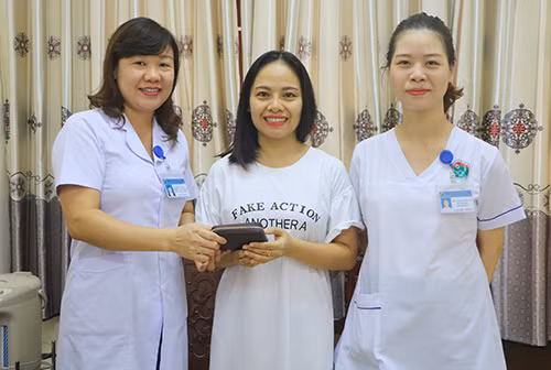 Chị Như (giữa), nhận lại ví tiền từ 2 nhân viên y tế. Ảnh: Đức Hùng