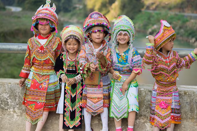 Các em bé gái Hmong cười thả ga trong trang phục truyền thống mừng năm mới. Sự đa dạng về tộc người, trang phục, lễ hội, ẩm thực của Việt Nam thu hút rất nhiều du khách trong và ngoài nước.