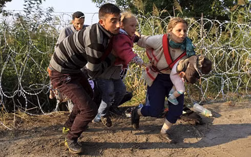 Người Syria luồn dây thép gai vượt biên vào châu Âu. Ảnh: Reuters.