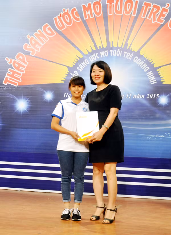 Đại diện Công ty TNHH Mặt trời Hạ Long trao quyết định đỡ đầu sinh viên Phùn Tài Múi, Trường Đại học Hạ Long.