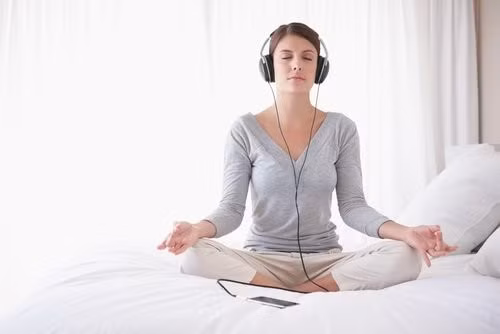 Thiền và nghe nhạc nhẹ là những việc bạn nên làm trước khi đi ngủ 30 phút để thư giãn tinh thần và ngủ ngon hơn. Ảnh: Top
