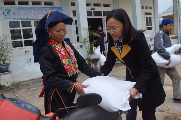 Giúp người dân đưa gạo lên xe.