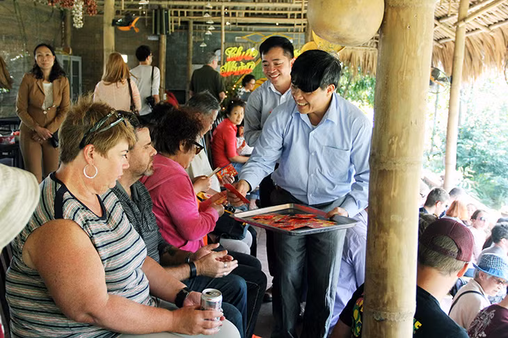 Lãnh đạo TX Đông Triều trao lì xì cho du khách tham gia tour du lịch Làng quê Yên Đức, ngày 12-2-2016.