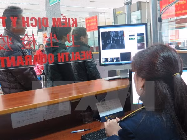 Giám sát chặt chẽ khách xuất nhập cảnh tại cửa khẩu quốc tế Lào Cai bằng máy đo thân nhiệt. (Ảnh: Lục Hương Thu/TTXVN)