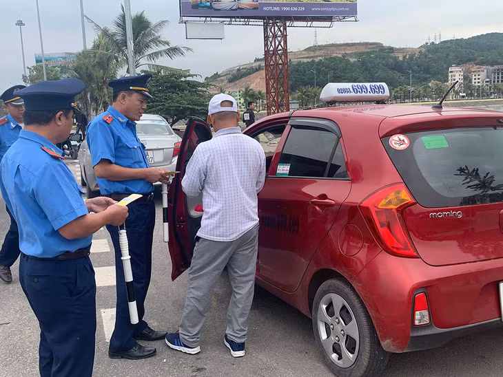 Cán bộ Đội TTGT số 2 kiểm tra nhắc nhở chủ phương tiện xe taxi tại Bến xe Bãi Cháy (TP Hạ Long).