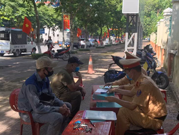 Cán bộ Đội CSGT-TT Công an TP Cẩm Phả lập biên bản người điều khiển phương tiện vi phạm Luật Giao thông.