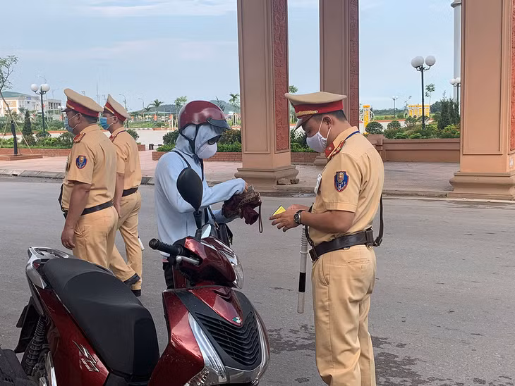 Cán bộ Đội CSGT Công an TX Đông Triều đang kiểm tra hành chính người điều khiển phương tiện tham gia giao thông trên địa địa bàn.