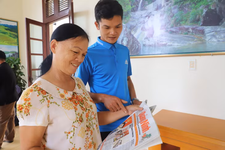 Người dân xã Lục Hồn, huyện Bình Liêu đọc báo theo dõi tin tức về Đại hội.