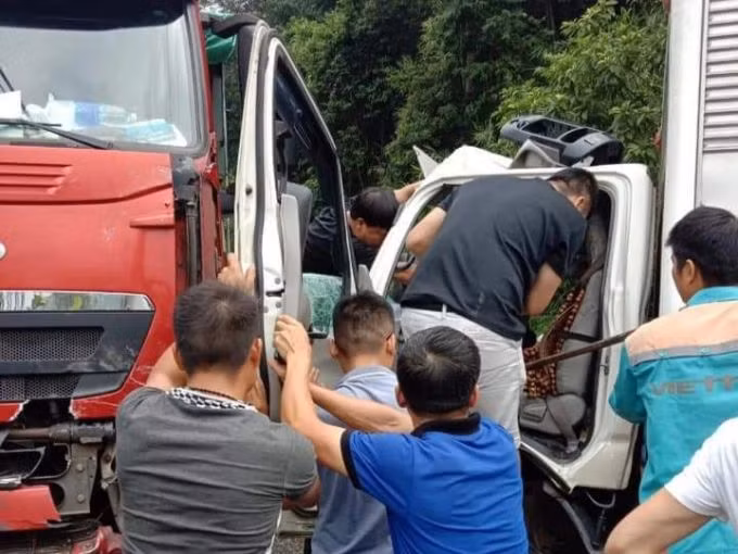 Người dân hỗ đưa lái xe thư báo bị thương mắc kẹt trên xe đi cấp cứu. Ảnh: Mạnh Cường.
