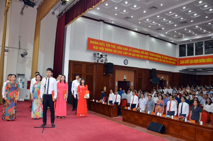 Các Đảng viên tuyên thệ dưới cờ Đảng và chân dung Chủ tịch Hồ Chí Minh