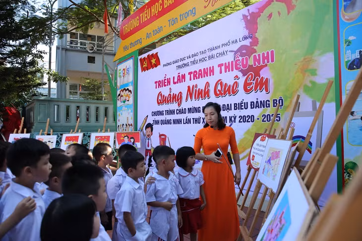 Cô giáo hướng dẫn cho học sinh xem tranh tại buổi triển lãm