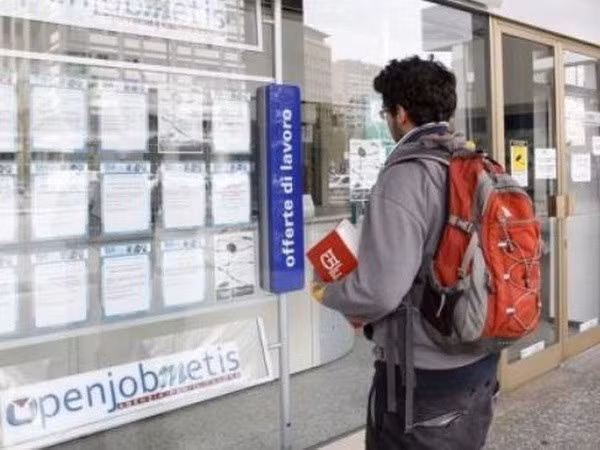 Một thanh niên xem thông báo tuyển dụng tại Milan, Italy. (Nguồn: presstv.i)