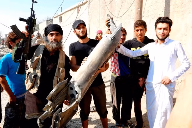 Phiến quân IS thu giữ mảnh vỡ một máy bay chiến đấu quân chính phủ Syria bị bắn hạ hồi tháng 9/2014 tại Raqqa. (Ảnh: Reuters)