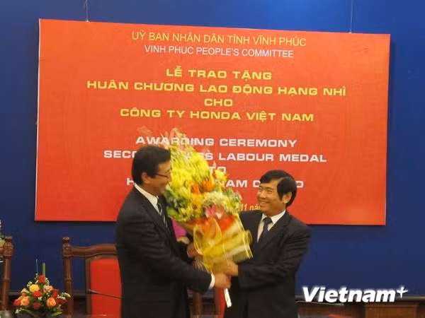 Ông Phùng Quang Hùng, Chủ tịch UBND tỉnh Vĩnh Phúc, trao Huân chương và lẵng hoa cho Công ty Honda Việt Nam.
