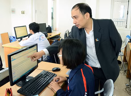 Thầy Nguyễn Hồng Thái hướng dẫn học sinh thực hành trong giờ tin học.